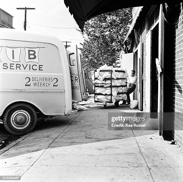 The owner of Crib Diaper Service unloads the day's cloth diapers at their office, Long Island, New York, June 1947.