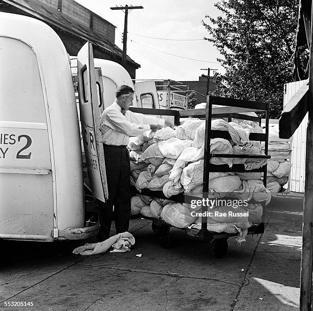 Delivery man for Crib Diaper Service unloads the day's deliveries of cloth diapers, Brooklyn, New York, New York, 1947.