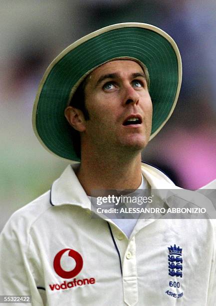 London, UNITED KINGDOM: England captain Michael Vaughn looks up at the sky as play between England and Australia is delayed due to bad light on the...