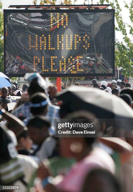 Sign displays a warning to Hurricane Katrina evacuees lining up to receive Red Cross debit cards at the Reliant Center, near the Astrodome September...