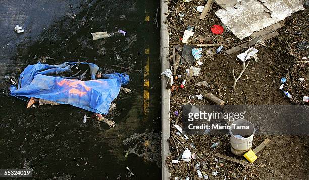 The body of a drowning victim is seen on a wet road September 9, 2005 in New Orleans, Louisiana. FEMA has asked the news media not to publish...