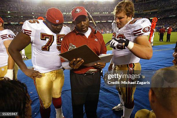 George Warhop meets with Jonas Jennings and Norm Katnik of the San Francisco 49ers during the preseason game against the San Diego Chargers on...