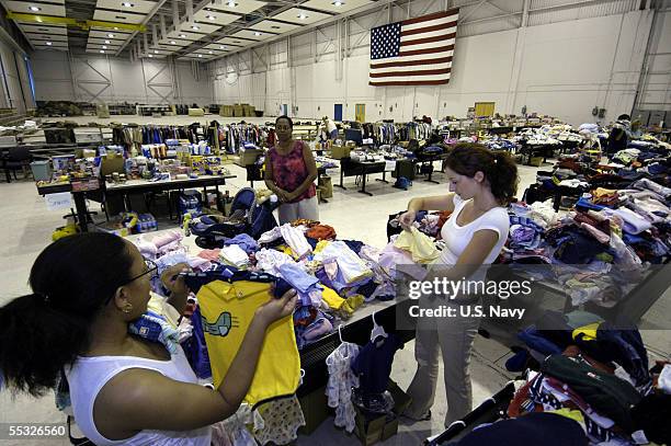 In this handout provided by the U.S. Navy, volunteers sort through baby clothes at the Hurricane Katrina Evacuee Supply Depot, which is housed in a...