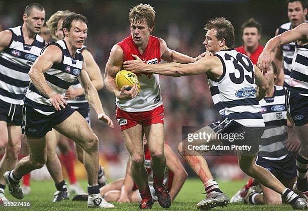 Ryan O'Keefe of the Swans is tackled by Darren Milburn of the Cats during the AFL Semi Final match between the Sydney Swans and the Geelong Cats at...