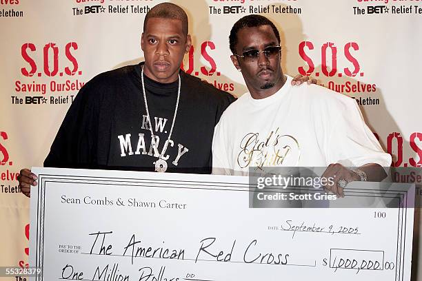 Rappers Jay-Z and Sean "P. Diddy" Combs hold a check for one million dollars that they will donate to the American Red Cross backstage during "S.O.S....