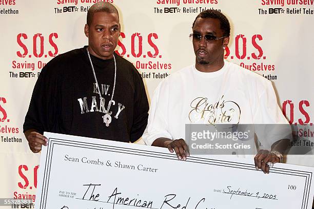 Def Jam President Jay-Z and Sean "P. Diddy" Combs hold a check for one million dollars that they will donate to the American Red Cross backstage...