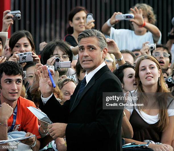 Actor George Clooney signs autographs for fans as he arrives for the Golden Lion Awards at the Palazzo del Cinema on the final day of the 62nd Venice...