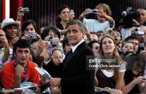 George Clooney signs autographs for fans as he arrives for the Golden Lion Awards at the Palazzo del Cinema on the final day of the 62nd Venice Film...