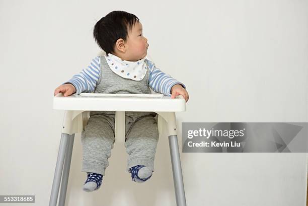 baby boy on baby chair looking left - left behind ストックフォトと画像