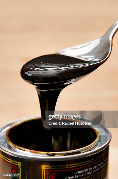 spoonful of black treacle oozing off of spoon - molasses bildbanksfoton och bilder
