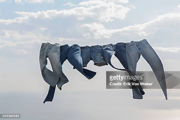 jeans hanging on a clothesline in the wind - pantalon fotografías e imágenes de stock