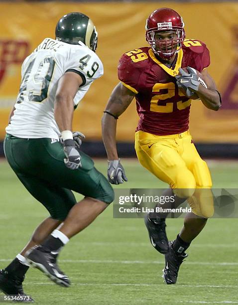 Running back Amir Pinnix of the Minnesota Golden Gophers tries to get past linebacker John Nichols of the Colorado State Rams on September 10, 2005...