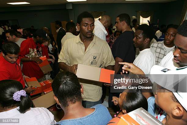 Ron Artest of the Indiana Pacers hands out pairs of sneaks to evacuees, who have been displaced by the effects of Hurricane Katrina during Kenny...
