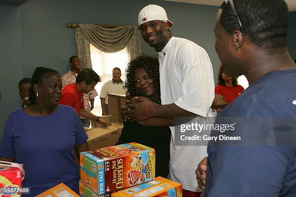 Jermaine O'Neal of the Indiana Pacers receives a hug from an evacuee, who has been displaced due to the effects of Hurricane Katrina, while O'Neal...