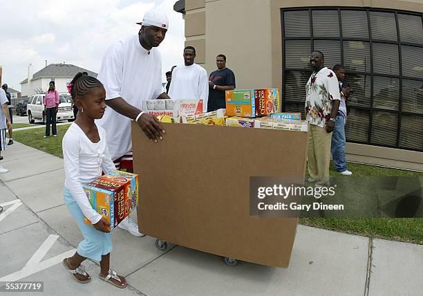 Jermaine O'Neal of the Indiana Pacers pushes a box of donated food for evacuees, who have been displaced due to the effects of Hurricane Katrina,...