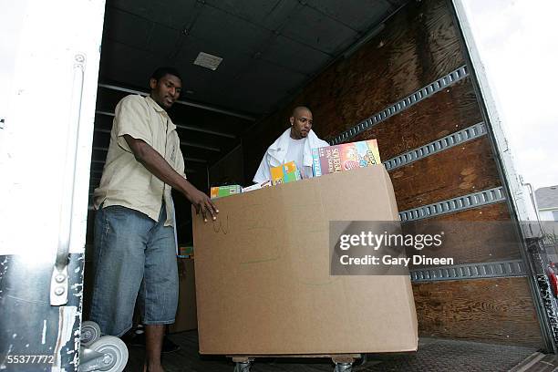 Ron Artest of the Indiana Pacers and Kenyon Martin of the Denver Nuggets unload a box o food which they are giving to evacues, who have been...