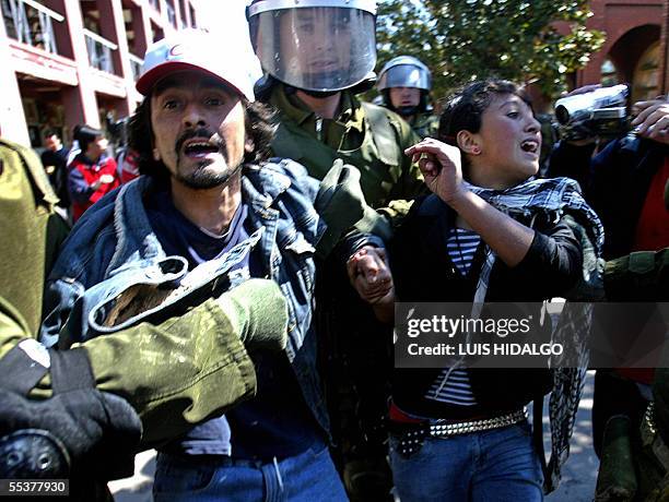 Un policia de Fuerzas Especiales detiene a manifestantes en Santiago, el 11 de setiembre de 2005, durante la conmemoracion de los 32 anos del golpe...