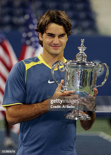 Roger Federer of Switzerland poses with the championship trophy after defeating Andre Agassi in the men's final of the US Open at the USTA National...