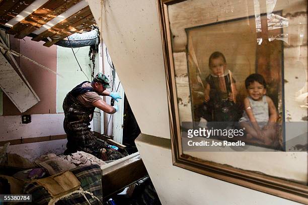 Specialist Anthony Bustillos from the New Mexico National Guard checks for bodies in a home destroyed after Hurricane Katrina passed through...