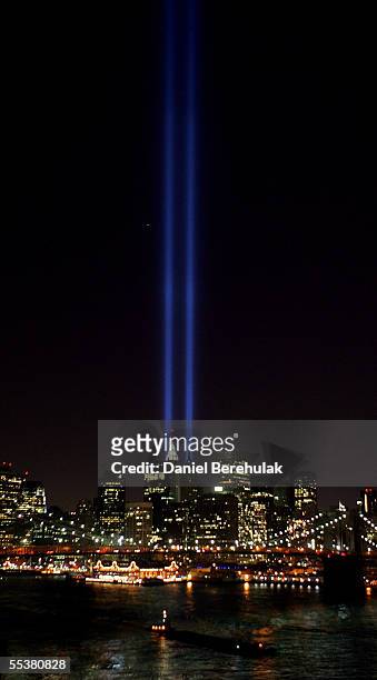 Beams of light shine into the sky behind the Brooklyn Bridge and above the Manhattan skyline on September 11, 2005 in New York City. The lights pay...