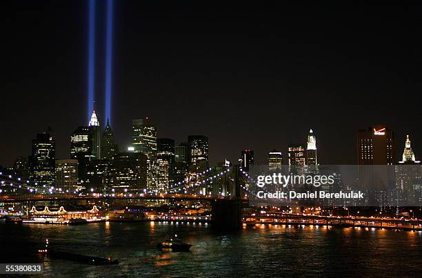 Beams of light shine into the sky behind the Brooklyn Bridge and above the Manhattan skyline on September 11, 2005 in New York City. The lights pay...