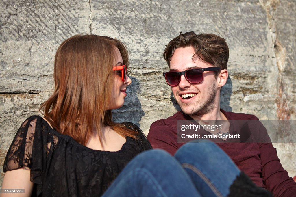 Young mid 20's couple sat looking at one another