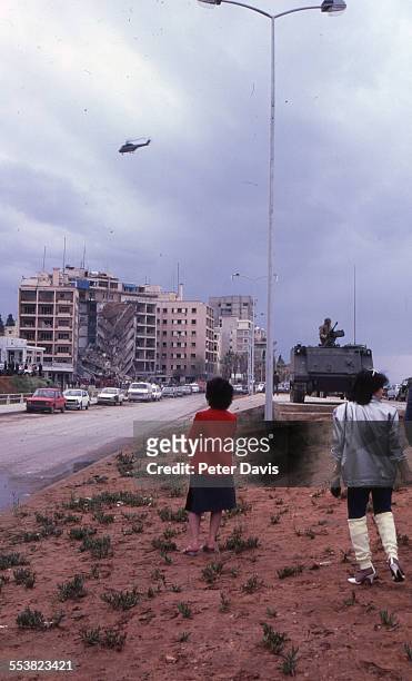 The collapsed facade of the American Embassy building is visible in the background as an onlookers view the scene from across the street, on the day...