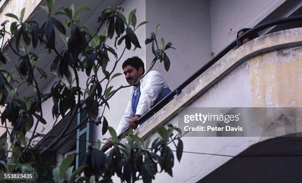 Onlookers at a nearby balcony view the destruction and damage at the scene of the suicide bombing of the American Embassy, Beirut, Lebanon, April 18,...