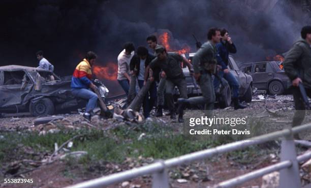 Soldiers and civilians carry the injured amid destruction and damage at the site of the suicide bombing of the American Embassy, Beirut, Lebanon,...