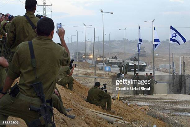 Israeli soldiers take photos as an Israeli armored convoy leaves the Gaza Strip September 12, 2005 through the Kissufim crossing between Israel and...