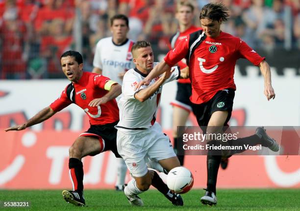 Altin Lala and Thomas Brdaric of Hannover tussels for the ball with Benjamin Kohler of Frankfurt during the Bundesliga match between Hanover 96 and...