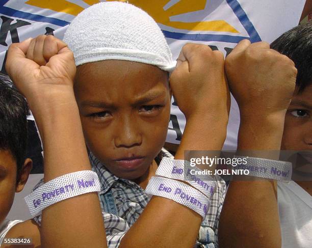 Filipino children display armbands which says "end poverty now" during a protest as demonstrators call for President Gloria Arroyo's ouster just...