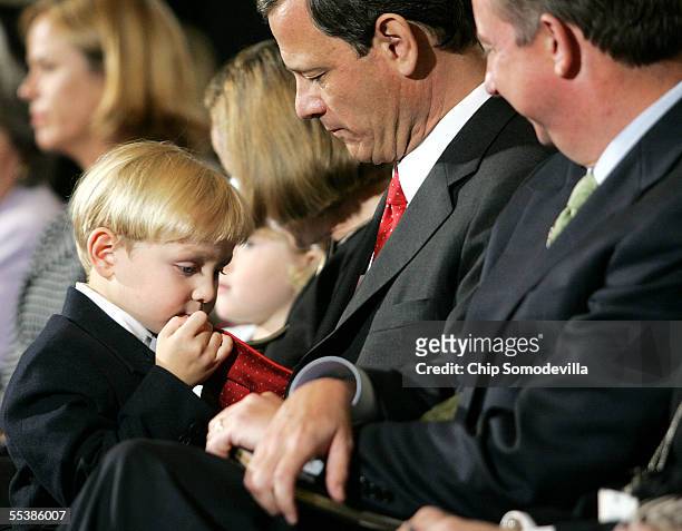 Jack Roberts , son of U.S. Supreme Court Chief Justice nominee John Roberts plays with his father's necktie on the first day of confirmation hearings...