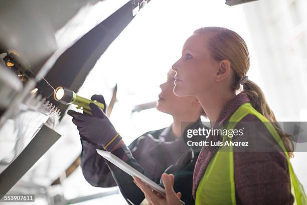 supervisor and engineer analyzing airplane part - aeroplane engineer stock pictures, royalty-free photos & images