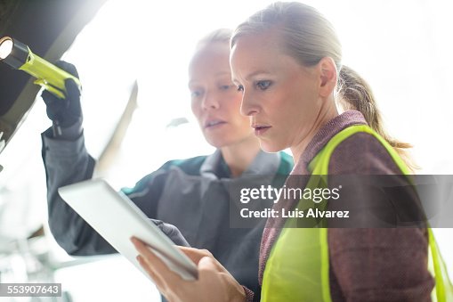 Supervisor and engineer using tablet PC at hangar Supervisor and engineer using tablet PC at hangar