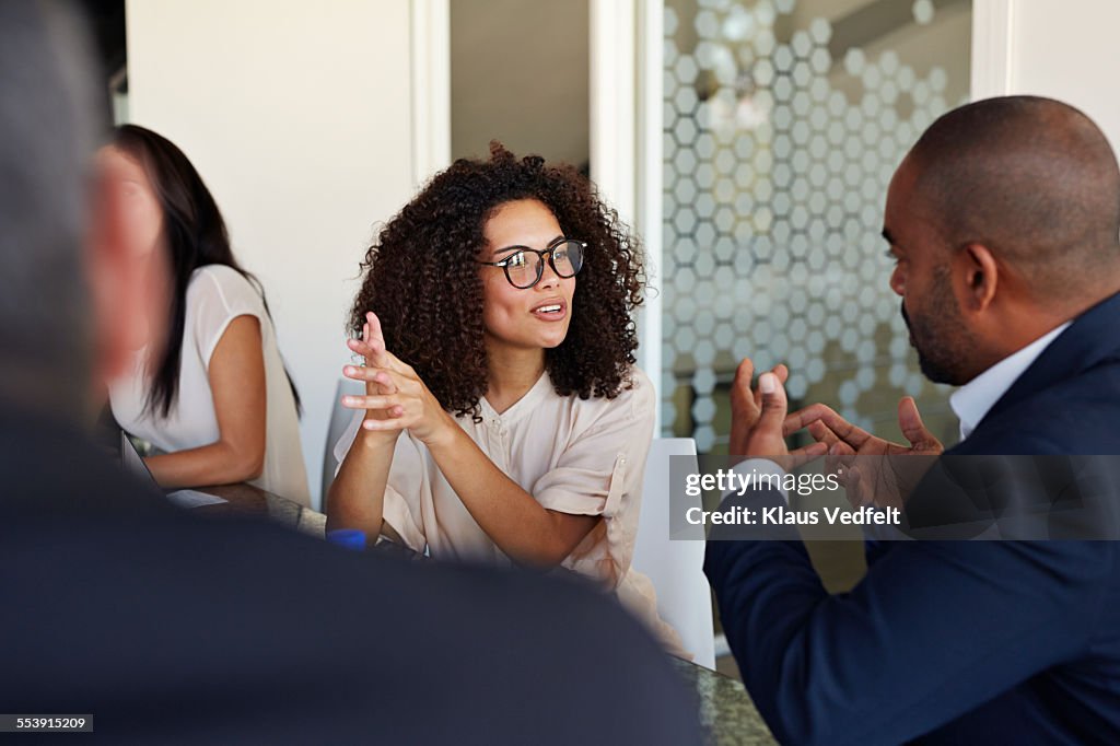 Businesspeople explaining and listening at meeting