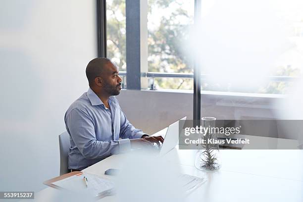 businessman with laptop looking out of window - office desk top view fotografías e imágenes de stock