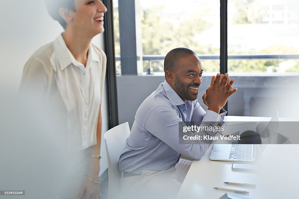 Coworkers in meetingroom laughing