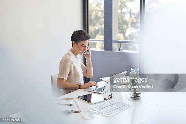 businesswoman on the phone & in front of laptop - red blouse fotografías e imágenes de stock