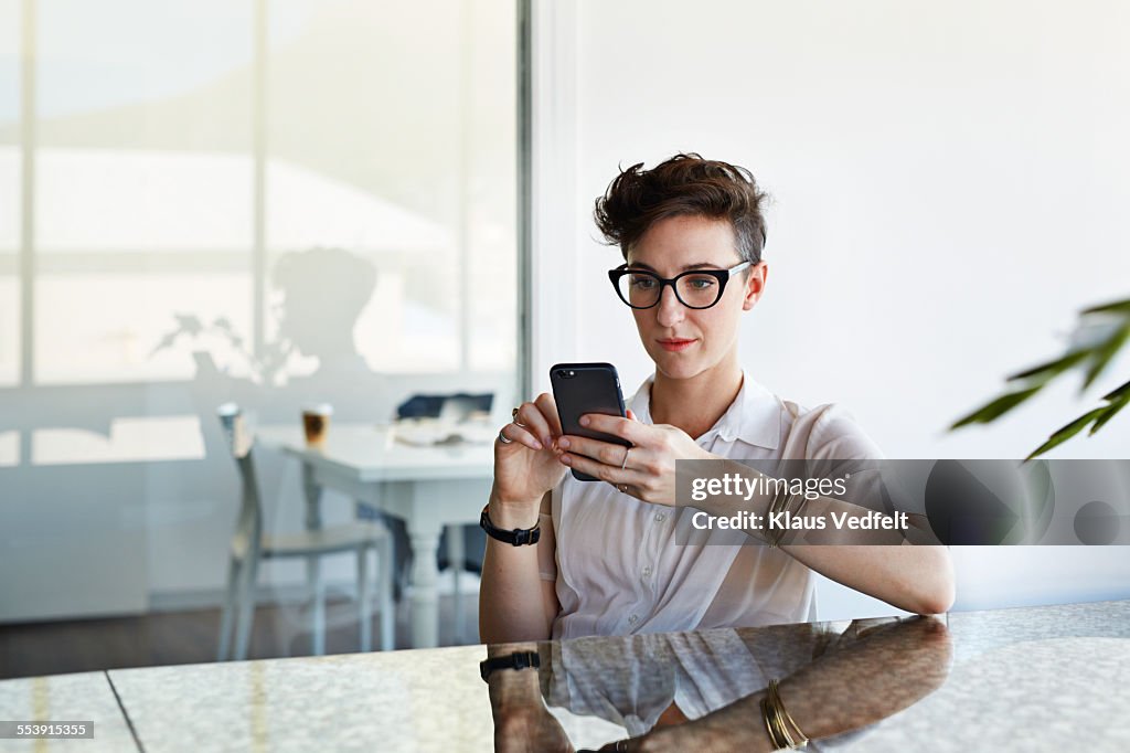 Cool businesswoman scrolling on phone