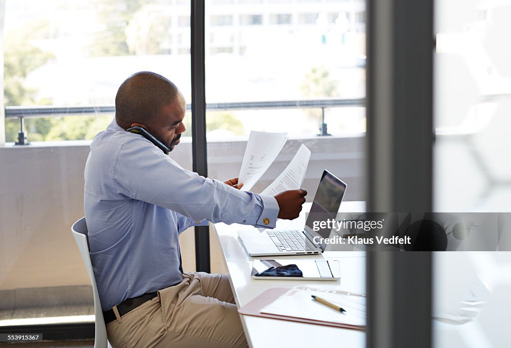 Businessman on phone and looking threw papers