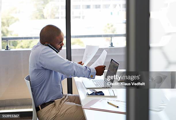 businessman on phone and looking threw papers - working office busy stockfoto's en -beelden