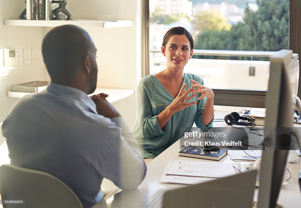 Businesswoman explaining to coworker