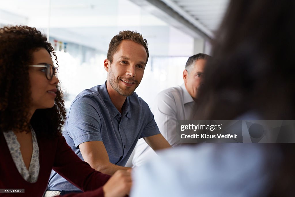 Businessman listening at coworker at meeting