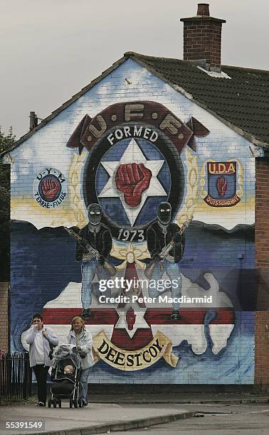 Local women walk past a mural in the mainly Loyalist area of East Belfast on September 13, 2005 in Northern Ireland. Ten police officers were injured...