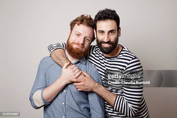 guy couple hugging and smiling - couples studio portrait stock-fotos und bilder