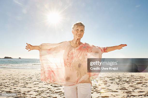 senior woman on the beach - blouse stockfoto's en -beelden