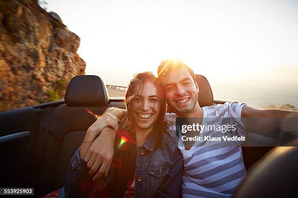 Couple with arms around each other in back of car