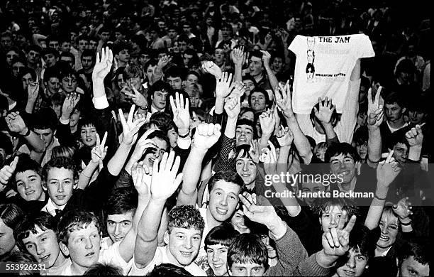 Fans gather excitedly, waving and cheering in the audience, at The Jam's farewell concert at the Brighton Centre, 11th December 1982.