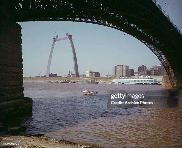 The Gateway Arch monument under construction in St. Louis, Missouri, USA, circa 1964. A temporary scissors truss has been placed between the...